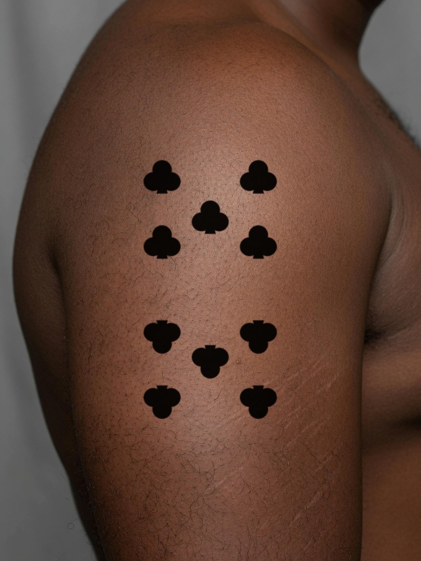 10 of Clubs pip tattoo on the upper arm