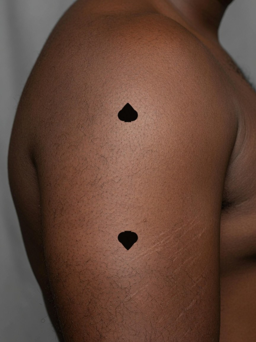 2 of Spades pip tattoo on the upper arm