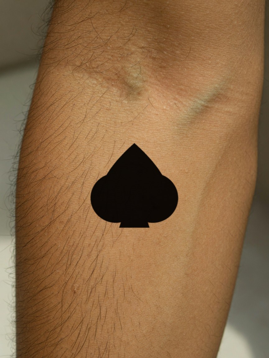 Ace of Spades pip tattoo on the outer forearm